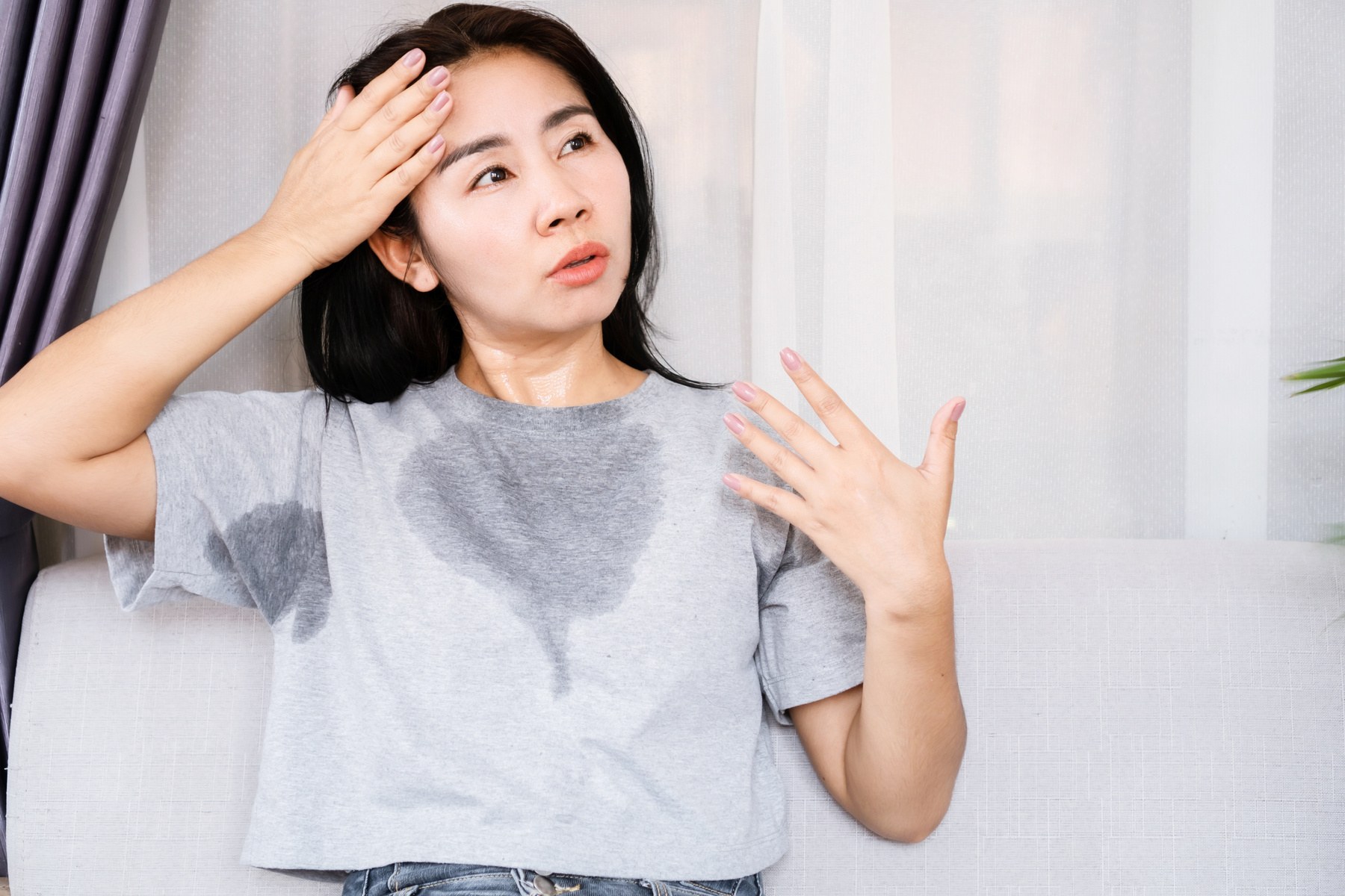 Asian woman sweating because of hot weather, heat stroke or menopause symptom concept